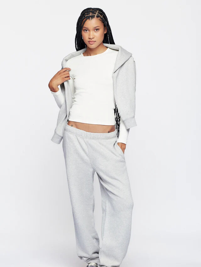 A model wearing a light grey Kotn zip up sweat set.