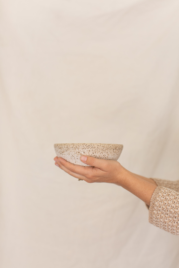 Women's hands holding handmade ceramic bowl.