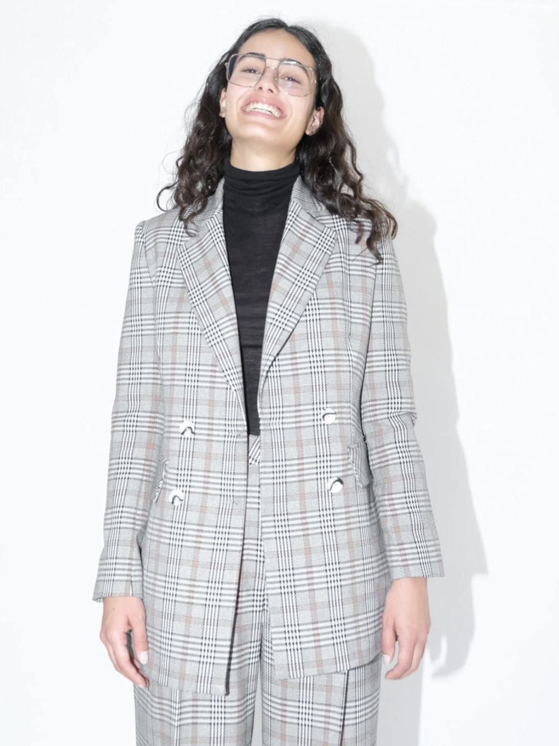 A model wearing a plaid blazer from Oh Seven Days