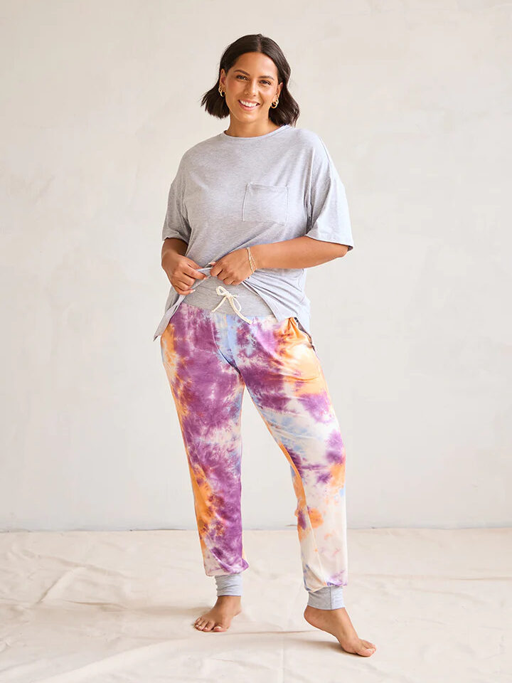 A model wearing a grey short sleeve and pink and orange tie-dyed pant pajama set by This is J.