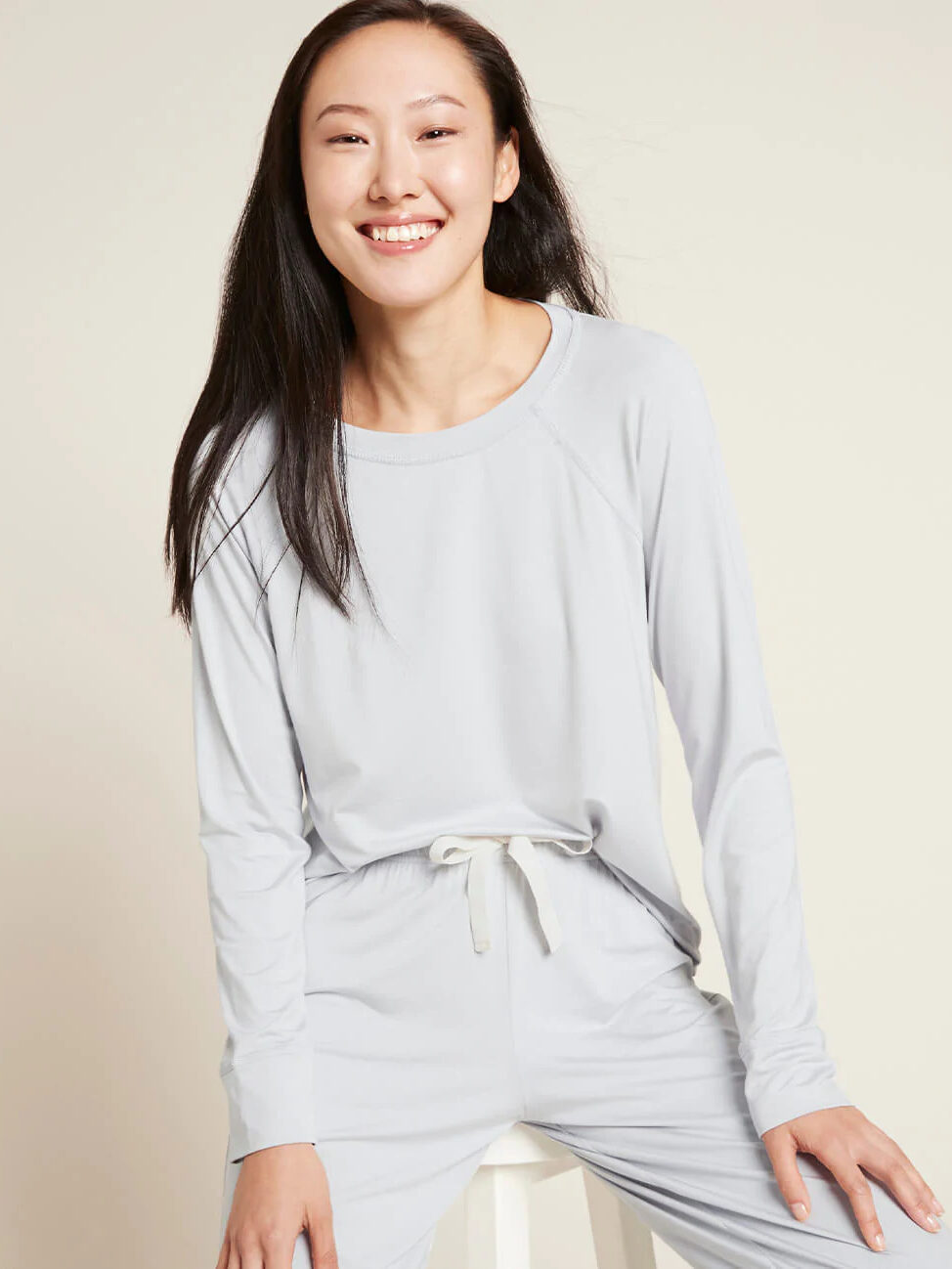 A model wearing a light grey long sleeve matching pajama set by Boody.