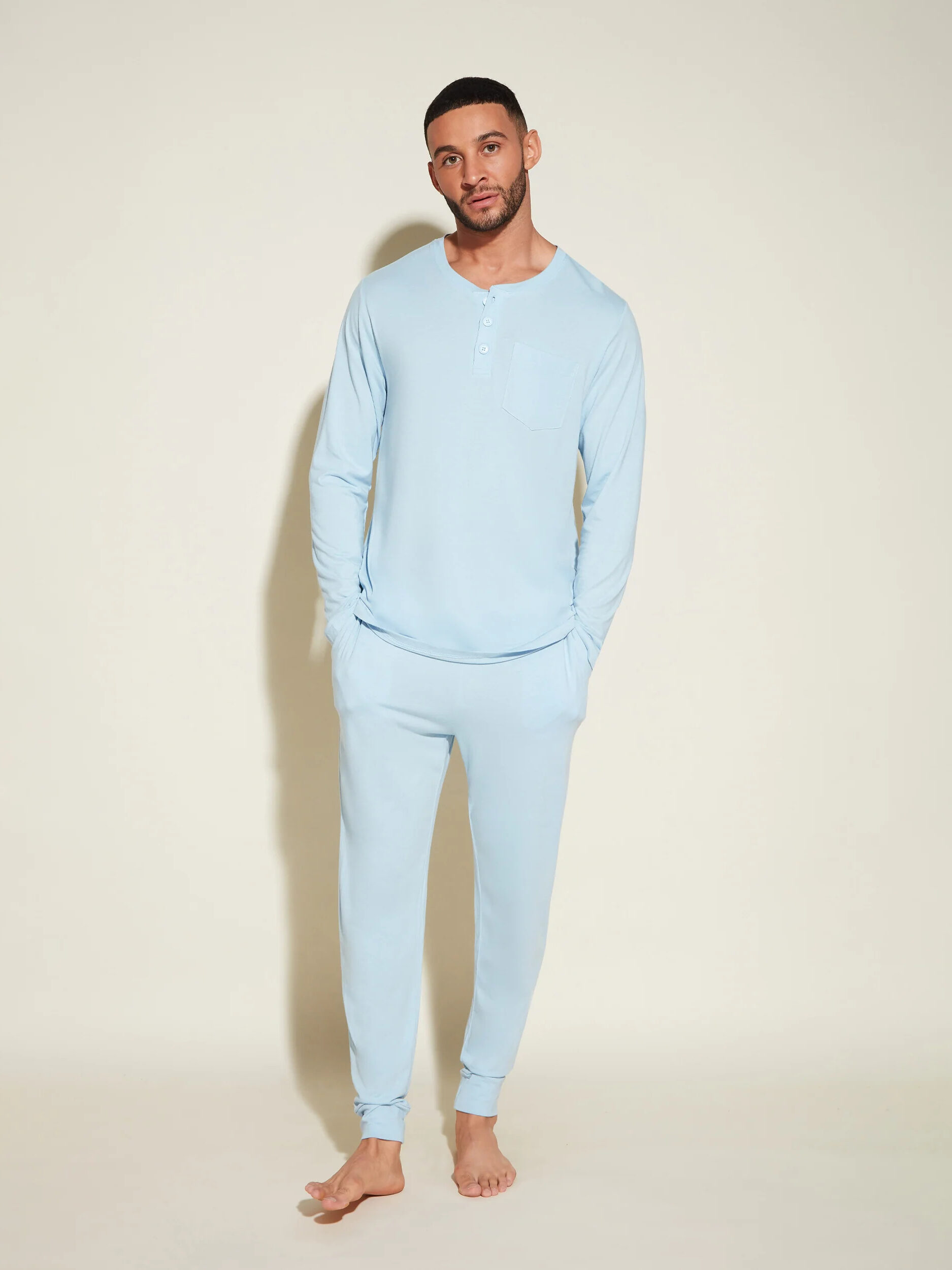 A model wearing a light blue long sleeve pajama set by Cosabella.