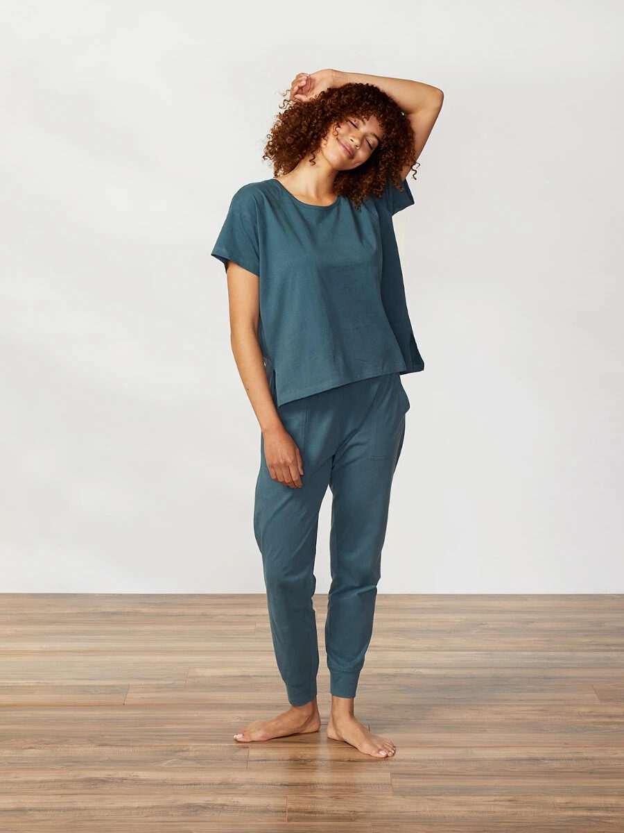 A model wearing a teal short sleeve matching pajama set by Coyuchi.